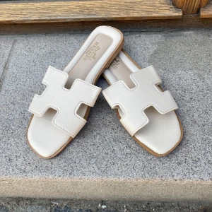  vita sandaler i skinn - Snygga sandaler i vitt skinn , De har fyrkantig tå och platt sula med präglad detalj undertill. Perfekta för en clean och lyxig look under varma dagar.