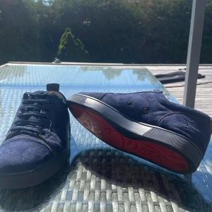 Blå mocka sneakers från Louboutin - Säljer dessa loubs i hyfsat bra skick, den har lite skada på inne sulan på ena skon men inget som känns av. Därför billigt pris och att ingen box tillkommer