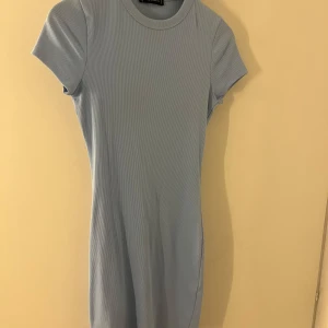 Ljusblå ribbad kortklänning FB Sister - Supersöt ljusblå ribbad kortklänning från FB Sister. Klänningen har rund halsringning, korta ärmar och en tight passform som framhäver figuren. Klänningen köptes förra sommaren och är använd 1 gång. 