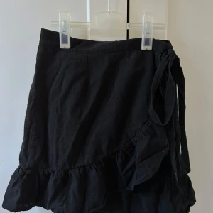 Svart omlottkjol med volang från NLY Trend - Så fin omlottkjol med knytning, perfekt till sommaren ☀️💞