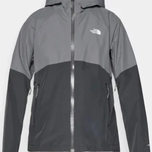 Grå vindjacka The North Face - Snygg tvåfärgad vindjacka från The North Face i mörkgrått och ljusgrått. Jackan har luva, hel dragkedja framtill och två sidofickor med dragkedja. Perfekt för blåsiga dagar och outdoor-äventyr.