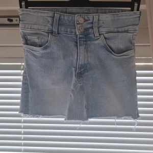 Ljusblå jeansshorts från H&M - Snygg ljusblå hemmasydd jeanskjol från H&M med låg midja. 
