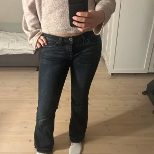 Lågmidjade bootcut jeans - Mörka jeans med mönster på fickorna, utsvängda 