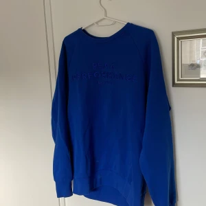 Blå tröja från Peak Performance - Säljer en snygg blå tröja från Peak Performance med broderad logga på bröstet. Tröjan har långa ärmar och en rund halsringning. Perfekt för en stilren och sportig look.