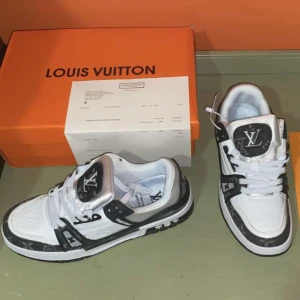 LV trainer - Snygga vita och svarta sneakers från Louis Vuitton med märkets logotyp på tungan och sidan. Skorna har en stilren design med snörning och detaljer i silver. Perfekta för den som vill ha en lyxig touch i vardagen. Helt nya med box och kvitto.