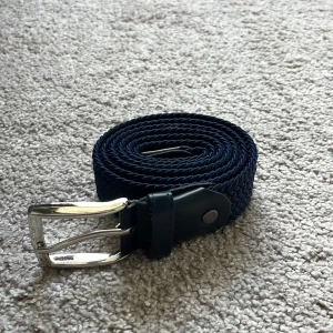 flätat bälte - säljer nu detta snygga flätade marinblåa bäldet som är i toppskick, helt nytt. Det är 115cm långt. Tveka inte att ställa några frågor.