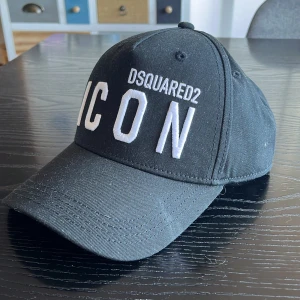 Svart keps från Dsquared2 - Riktigt snygg svart keps från dsquared2, kepsen är helt i nyskick och är aldrig använd, säljes nu för att den aldrig kommer till användning. Passar alla huvuden för att man kan justera storlek, lapp sitter kvar med pris tagg, pris kan eventuellt diskuteras lite men inte för mycket då det redan är bra pris.  om ni har frågor är det bara att skriva privat😁