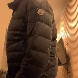  Moncler - Säljer en stilren mörkblå jacka från Moncler. Jackan har en quiltad design med dragkedja framtill och två praktiska fickor. Perfekt för kyligare dagar. Kan gå ner vid pris vid snabb affär! Bara att kontakta vid eventuella frågor.
