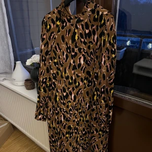 Leopardmönstrad klänning från Y.A.S - Snygg leopardmönstrad klänning från Y.A.S i en härlig brun nyans. Klänningen har långa ärmar och en avslappnad passform som gör den perfekt för både vardag och fest. Ett måste för garderoben!