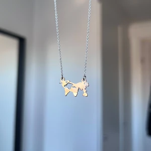 Halsband med världskarta i silver - Unikt halsband med en världskarta i silver på en tunn kedja. Perfekt för den som älskar att resa eller vill ha en stilren accessoar med en personlig touch. Önskar du veta exakta mått? Tveka inte att höra av dig!