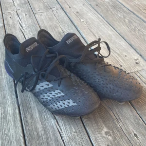 Svarta fotbollsskor Adidas Predator - Adidas predator freak skor i mycket bra skick bara använda ca 10 gånger! De har gummi spikar på överdelen, alla sitter kvar! Storlek 43 1/3 Hör av er om frågor