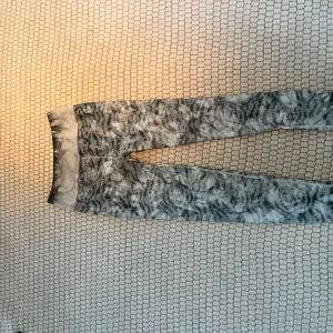 Grå / gröna mönstrade leggings - Snygga grå leggings med ett unikt mönster som ger en cool look. Perfekta för en avslappnad stil eller för att sticka ut lite extra. De har en elastisk midja för bekväm passform.