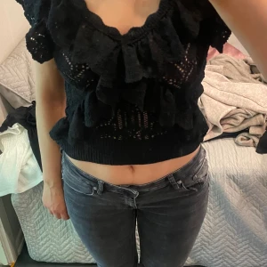 Svart stickad topp med volang - Säljer en svart stickad topp med volangdetaljer och en v-ringad design. fint skick!❤️