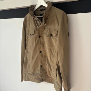 Beige jacka från J.Lindeberg - Snygg beige jacka från J.Lindeberg med dragkedja och knappar framtill. Helt okej skick, pris - 499kr - vid frågor eller funderingar är att skriva!