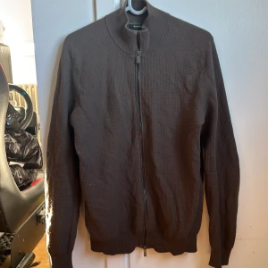 Brun kofta från Massimo Dutti - Säljer en stilren brun kofta från Massimo Dutti i bomull. Koftan har en dragkedja framtill och långa ärmar. Perfekt för en avslappnad och snygg look.