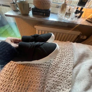 Svarta sneakers Anna Field - Snygga svarta slip-on sneakers från Anna Field med en unik knytdetalj på ovansidan. Skorna har en vit sula som ger en fin kontrast och är perfekta för en stilren look💫 superfint skick och jätte härliga! 💞 kom med bud och håll inte tillbaka någon fråga! 