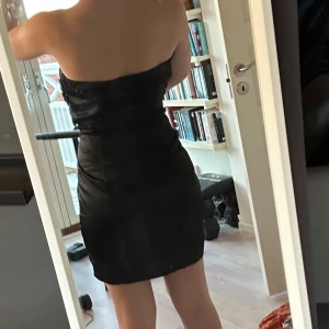 Festklänning bandeau  - Riktigt snygg svart kort klänning utan axelband❤️‍🔥Fina detaljer upptill som gör klänningen unik och mer exklusiv! Tyvärr lite för stor för mig som är en S men hade suttit mycket bättre på en storlek M med lite större byst😩😍
