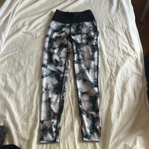 Mönstrade leggings från SOC - Snygga leggings från SOC med högt svart midjeband och ett unikt geometriskt mönster i vitt, blått och rosa. Tillverkade i stretchigt syntetmaterial och midjebandet som stöd som passar perfekt för träning eller chill. Supersköna och sitter på plats hela passet.