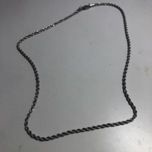 Silver kedja 46 cm, 56 cm - En stilren och tunn halskedja i silverfärg med tvinnad design. Perfekt för dig som gillar minimalistiska smycken och vill ha något som funkar till alla outfits. Kedjan har ett klassiskt lås och passar både ensam eller i lager med andra halsband.