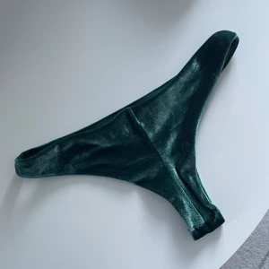 Bikiniunderdel - Bikiniunderdel i sammet med söm bak i grön/turkos färg. Lapp avklippt men strl S. Fint skick!