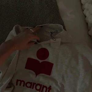 Grå sweatshirt från Isabel Marant - Grå sweatshirt från Isabel marant med rött/vinrött tryck där fram ❤️ älskar denna tröja och den är använd en del men inga defekter alls. 