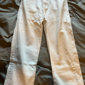 Vita straight jeans från Never Denim - Snygga vita jeans från Never Denim med låg midja och raka ben. Klassisk femficksmodell i bomullstyg, perfekta för en clean och fräsch look. Passar dig som gillar enkel stil med edge.