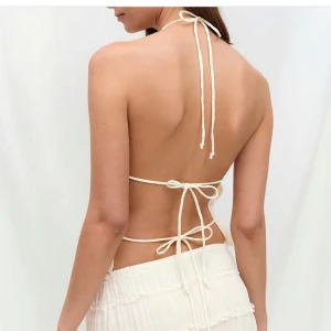 Vit omlott halterneck linnetopp - Säljer denna populära slutsålda vita halterneck toppen med knyt i nacken och ryggen då jag köpte fel storlek. Toppen är helt oanvänd med prislapp kvar. Hör av dig vid intresse. 