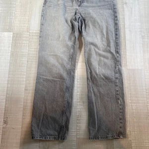 Grå raka jeans från Zara - Snygga grå jeans från Zara i rak modell med klassisk femficksdesign och knappgylf. Jeansen har en cool tvättad look och är tillverkade i bomull. Perfekta för dig som gillar en avslappnad och stilren vibe.