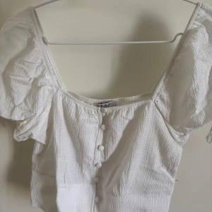 Vit blus med puffärm  - Supersöt vit blus från OXXO med puffiga korta ärmar och knappar framtill. Använd en gång och i bra skick. Perfekt för en trendig men enkel look. Skriv för fler frågor ❤️