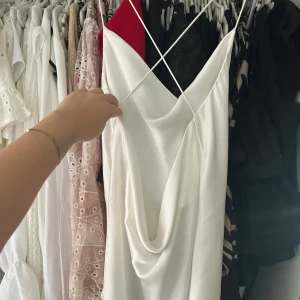 Vit mini silkes klänning - Super fin kort klänning med öppen, korsad rygg, köpte en på Vinted men tyvärr för liten för mig. Kolla bild finns ett hål i klänningen men syns ej så mycket när den är på! 🩷💕