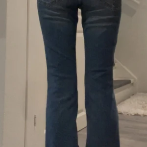 Blå bootcut jeans från Esprit - Snygga blå jeans från Esprit i bootcut model. Jeansen har fem fickor, bälteshällor och dragkedja med knapp. Materialet är jeans i bomull med en lätt stretch för extra komfort. Dom är vintage och säljs därav inte längre! 