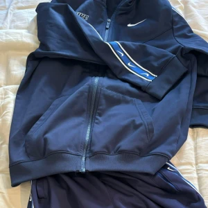 Blå Nike kofta och byxa  - Blå Nike kofta och byxa som är i nytt skick pris kan diskuteras