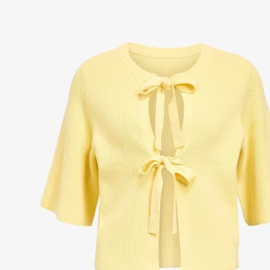 Gul kofta med knyt fram - Superfin ljusgul kofta i ribbstickad bomull med två knytband framtill. Koftan har trekvartsärmar och en croppad passform som ger en fräsch och trendig look. Perfekt att slänga över ett linne eller klänning för en söt vibe.nypris 599kr. Ny , bara testad. 