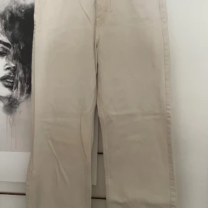 Beiga högmidjade jeans Weekday - Snygga beiga jeans från Weekday, modell Rowe High Straight. De har hög midja och raka ben för en clean och modern look. Perfekta till sneakers eller boots och tillverkade i ett mjukt bomullstyg.