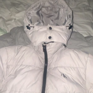 Ljusbeige pufferjacka Calvin Klein - Ljusbeige pufferjacka från Calvin Klein – Strl S Snygg och varm jacka, passar höst/vinter. Klassisk CK-logga på bröstet och även på armen. Använd få gånger, mycket fint skick. Nypris: ca 1500 kr. Säljes för 850 kr eller bud. Kan skickas eller mötas i Vingåker 