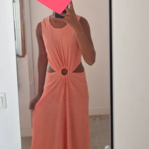 SUPERSNYGG klänning - Världens snyggaste klänning. Jag har använt den 2 gånger på festliga tillfällen. Den har en cirkel vid naveln och sitter lite oågmidjat där dey öppnas på kanterna. Den går ut jätte fins längst bak och sitter super fint! Säljer då den är för kort