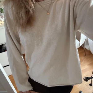 Beige stickad tröja från H&M - Enkel och stilren beige stickad tröja från H&M. Tröjan har rund halsringning, långa ärmar och en relaxed passform. Perfekt att slänga på sig över ett linne eller t-shirt. Mjuk och skön känsla, passar till allt.