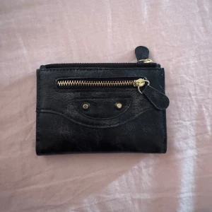 City bag plånbok  - Snygg svart plånbok i skinn med guldiga detaljer och dragkedja framtill. Plånboken har flera kortfack, fönster för ID och ett separat myntfack med tryckknapp. Köpt från en secondhand butik men helt nytt 