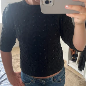 Svart stickad tröja med pärlor - Snygg svart stickad tröja med pärldetaljer och halvkort ärm. Superfin till hösten! Från Zara