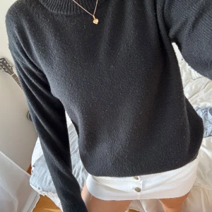 Svart stickad tröja från H&M - En svart stickad tröja från H&M i storlek S. Tröjan har rund halsringning med ribbade detaljer och långa ärmar. Enkel och stilren modell som är lätt att matcha med olika outfits. Perfekt för kyligare dagar.