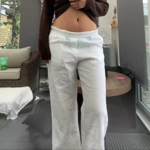 Vita linnebyxor med resårmidja - Säljer ett par oanvända vita linnebyxor med avslappnad passform och resår i midjan. Dem är lite genomskinliga så passar bra som strandbyxor ✨  