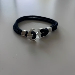 Marinblått armband- marint och snyggt - Snyggt armband i djup marinblå färg med nautisk vibe. Perfekt detalj till en clean outfit. Passar både tjejer och killar. Justerbar storlek, bekväm att bära och stilren nog för både vardag och fest. Säljs pga rensning – nyskick! 