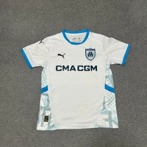 Olympique de Marseille Hemmatröja 2024/25 - Säljer en helt ny och officiell Olympique de Marseille hemma tröja för säsongen 2024/25, tillverkad av Puma. Denna tröja bärs av laget under hemmamatcher på ikoniska Stade Vélodrome och representerar klubbens rika historia och starka identitet.