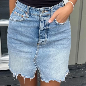 Jeanskjol - Snygg ljusblå jeanskjol i storlek 34. Kjolen är i jättebra skick då den knappt är använd.