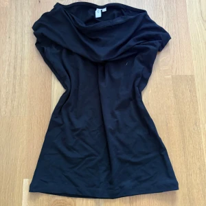 Svart och vit ärmlös topp - Två enkla och stilrena toppar i svart och vitt. Båda har en lös passform med bred halsringning och ärmlös design. Perfekta att matcha med jeans eller kjol för en clean look. Mjukt material som känns skönt mot huden.