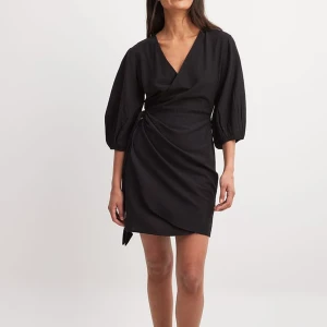 Svart miniklänning med omslag - Omlottklänning, storlek 38 men passar även 36! Aldrig använd, från nakd