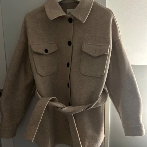 Beige jacka från NLY Trend - Snygg beige jacka från NLY trend med knappar och bälte i midjan💕