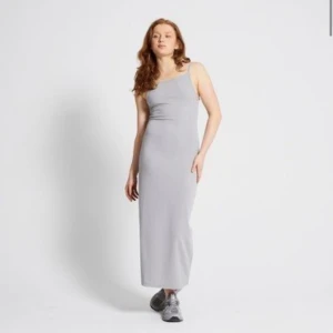Ljusgrå långklänning med smala axelband - Supersnygg ljusgrå långklänning med smala axelband och rak passform. Klänningen är ärmlös och har en minimalistisk look som är lätt att styla. Perfekt för dig som gillar enkel och stilren design. Den är ny, köpte från Lger 157. Rök och djurfritt hem