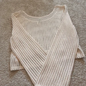 Strandtopp off shoulder - Superfin virkad topp som är perfekt för stranden! Vida ärmar, luftig och skön och passar perfekt för en stranddag! Bra skick utom en liten repa i sömnen (se bild). Kan även ha tröjan off shoulders