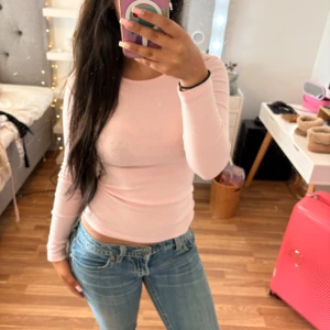 Ljusrosa långärmad topp EP Collection - Säljer en ljusrosa långärmad topp från EP Collection. Modellen är tight och har en klassisk rund halsringning. Perfekt att styla med jeans eller kjol för en clean look. Materialet är mjukt och stretchigt, troligtvis bomull.